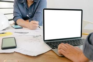 Mockup image of engineers using laptop to drawing design building Project in office, mockup concept photo