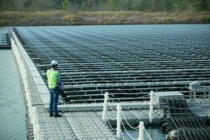 Engineer inspector holding laptop and working in solar panels power plant checking photovoltaic cells and electricity production. photo