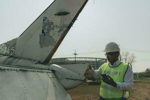 Aircraft mechanic examining airplane wing photo