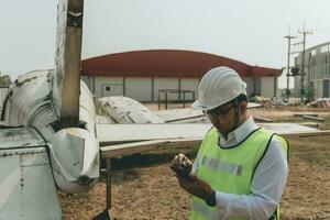 Aircraft mechanic examining airplane wing photo