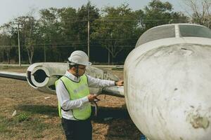 Aircraft mechanic examining airplane wing photo