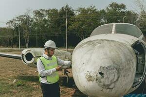 Aircraft mechanic examining airplane wing photo