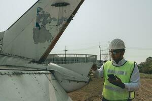 Aircraft mechanic examining airplane wing photo