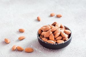 Fresh peeled almonds in a bowl on a light background. A source of vitamins and oils. Organic food photo