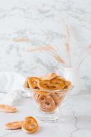 bávaro pretzels en un vaso cuenco en el mesa. bocadillo para rápido alimento. vertical vista. Copiar espacio foto