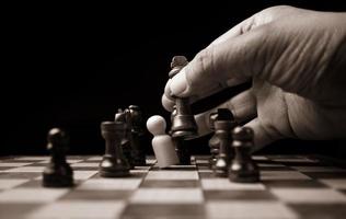 Close up of hands confident businessman moving chess figure in competition success play. the chess game is development analysis, strategy, and plan, the management or leadership concept. photo