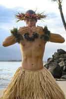 un tradicional hula danza en cuales masculino intérpretes soplar Besos lejos utilizando su palmas foto