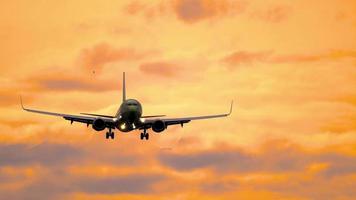 vicino su tiro di un' passeggeri aereo volante nel il tramonto nuvoloso cielo. bellissimo d'oro tramonto. aereo di linea silhouette nel il sera cielo video