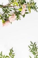 hermosa delicado floral antecedentes con Copiar espacio. fiesta tarjeta, disposición. vertical vista. plano laico de rosado claveles y verde hojas. marco. foto