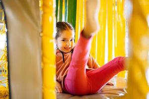 Little girl kid slide at yellow playground park. Child in active entertaiments. photo