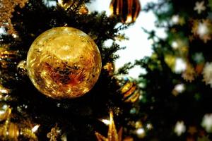 Glitter Ornament Ball on Christmas Tree with Beautiful Bokeh Background. photo