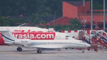 PHUKET, THAILAND NOVEMBER 27, 2019 - Lowcost Airbus A320 216, HS BBG of AirAsia taxiing at Phuket Airport. Private plane of Gulfstream G650, VQ BAH in the foreground. Tourism and travel concept video