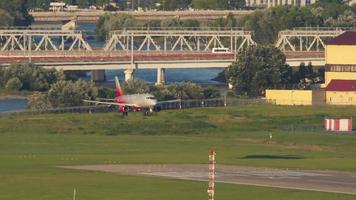 sotsji, Rusland juli 28, 2022 - sukhoi superjet van rossiya luchtvaartmaatschappijen landen, aanraken en remmen Bij Sotsji luchthaven, lang schot. toerisme en reizen concept video