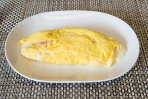 yellow omlette serves on white plate photo