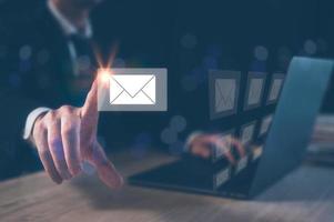 Email concept, businessman using computer laptop on table in office blurred background photo