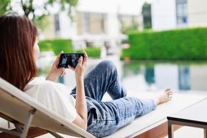 Travel Technology, Woman Uses Smartphone to Plan and Share Vacation Experiences by the Pool photo