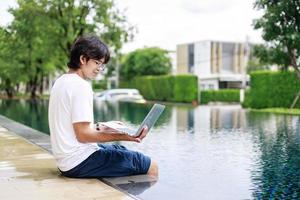 Laptop Work by the Poolside for Businessman on Vacation in Casual Wear photo