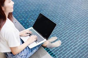 Investor Balances Business and Leisure by Trading Stocks Poolside in Rural Real Estate Hotel photo