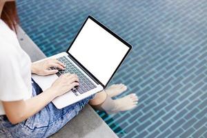 Business Woman Trades Stocks in Tranquil Rural Hotel Setting by Swimming Pool photo