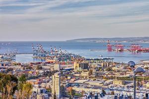 Sea port in the city of Haifa, panorama of the port and city buildings against blue sky with clouds photo