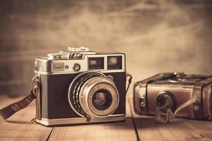 Old retro camera on vintage background. 90's concepts. Vintage style filtered photo. photo