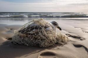 Bird, seagull trapped in plastic garbage lying on the beach. The concept of an ecological disaster caused by plastic garbage. photo