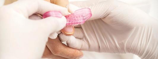 Manicurist brushing dust from nails photo