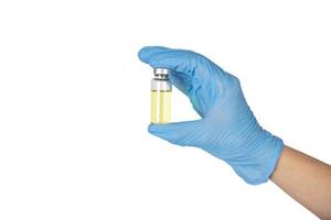 A doctor's hand in medical gloves holds an ampoule of vaccine. white background. Copy space. photo