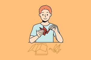 Smiling little boy sit at desk make origami. Happy kid enjoy hobby activity making birds from paper. Vector illustration.