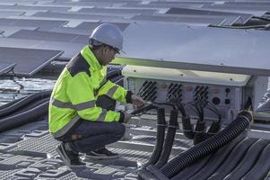 Asian engineer working at Floating solar power plant,Renewable energy,Technician and investor solar panels checking the panels at solar energy installation photo