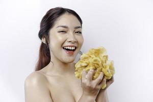 Portrait of happy Asian girl taking shower with gel. She washing with puff, body care beauty concept. photo