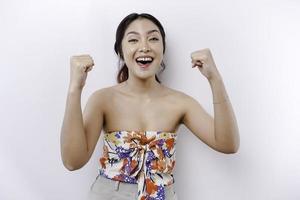 A young Asian woman with a happy successful expression wearing floral top isolated by white background photo