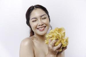 Portrait of happy Asian girl taking shower with gel. She washing with puff, body care beauty concept. photo