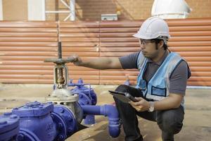 Engineer checking the water supply valve,Plumbing maintenance technicians open and close the main water supply. photo