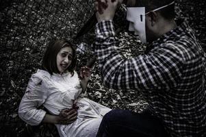 A serial killer scene is about to kill an Asian woman,concept thriller scene,Halloween festival photo