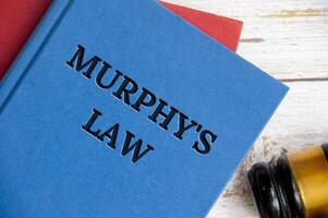 Top view of Murphy's Law book on wooden table with gavel background photo