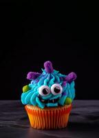 Funny cupcake for kids on dark background with copy space. Happy Birthday, Halloween dessert. Children's party. Empty space for text. Postcard, greeting card design. Monster muffin. . photo