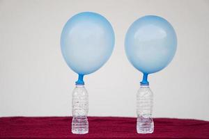 Blue inflated balloons on top of transparent test bottles. Concept, science experiment about reaction of chemical substance, vinegar and baking soda that cause balloon inflat. Last step of experiment photo