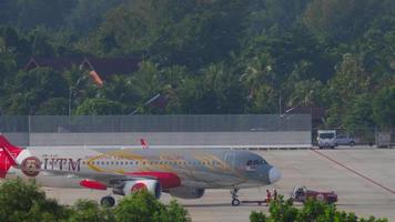 PHUKET, THAILAND NOVEMBER 29, 2019 - Tractor towing Airbus A320 216, 9M AJE of AirAsia Universiti Teknologi Malaysia Livery to the terminal at Phuket airport video