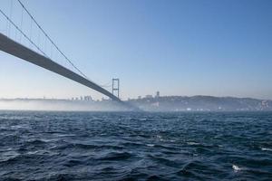 The Bosphorus Bridge across the Strait on a sunny and foggy day. photo