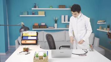 Funny boy in doctor uniform and stethoscope sitting at the working table of his doctor parents. video