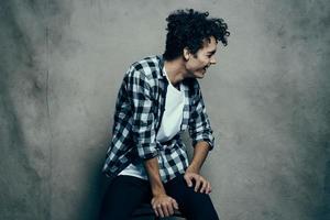 Cheerful guy curly hair plaid shirt Studio gray background photo