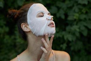 Beautiful woman anti-aging mask Holds his hand near his face tilt his head back bare shoulders photo