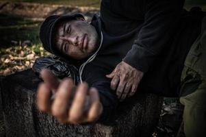 un hombre asiático no tiene hogar en la calle lateral, un extraño tiene que vivir solo en la calle porque no tiene familia. foto