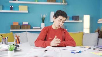 il pigro ragazzo chi è annoiato con studiando fermate studiando e sembra lontano. il pigro ragazzo chi fa non volere per studia fermate studiando e sembra lontano. video