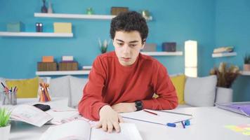 el niño, quien es aburrido con estudiando, descansa un pequeña. el niño estudiando a el escritorio obtiene aburrido y obtiene algunos descansar. video