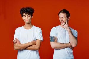 two friends in white t-shirts construction teams he emotions red background photo