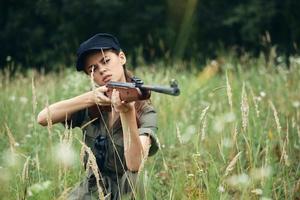 militar mujer pistola en mano es un caza estilo de vida verde mono foto