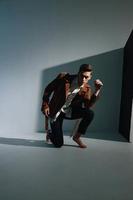 handsome man in brown jacket and trousers in a damp room is kneeling photo