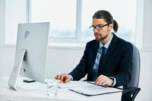 hombre en un traje un oficial es trabajando a el computadora tecnologías foto